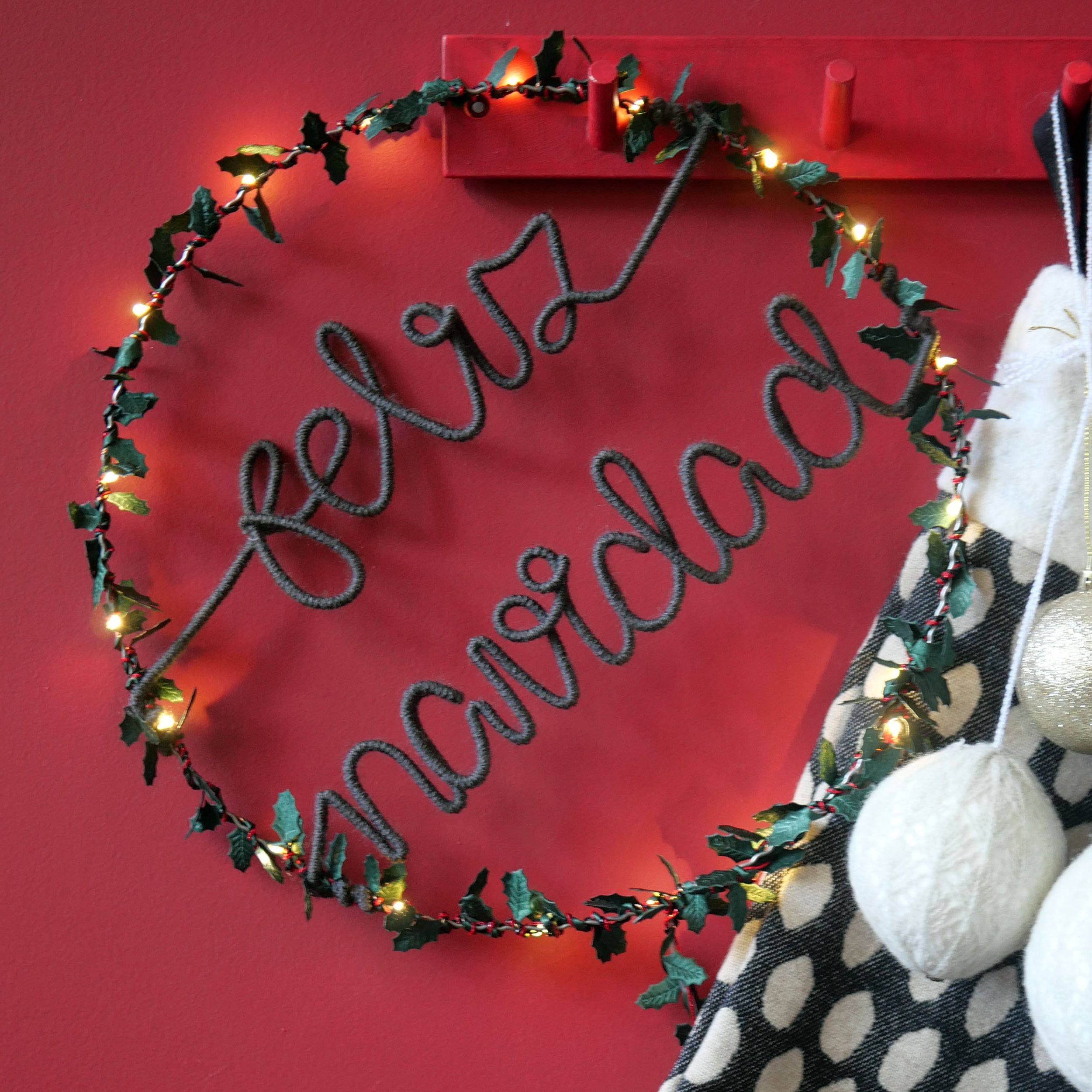 Feliz Navidad Christmas wreath with warm grey lettering on red background
