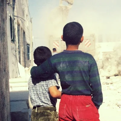 image: 2 Palestinian children watching their house demolished by the Israeli Military taken by Eric Fistler, Dheisheh Refugee Camp in Bethlehem 2004