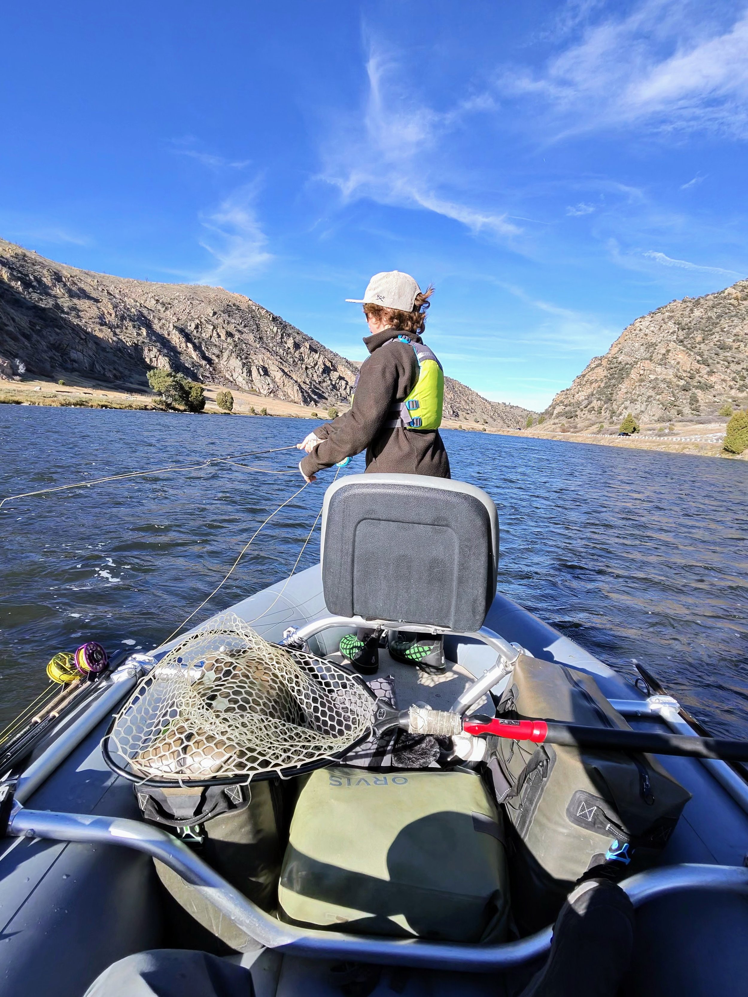 Solomon, fly fishing from the front of a raft during a guided float trip on the Lower Madison River.