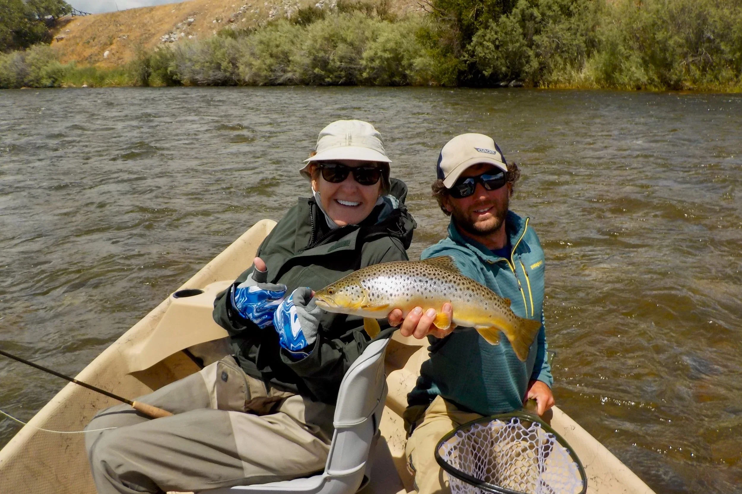 Professional guide David Kern and a smiling guest with a wild brown trout on the Madison River, showcasing the high-quality fishing experience with Flyshot Outfitters.