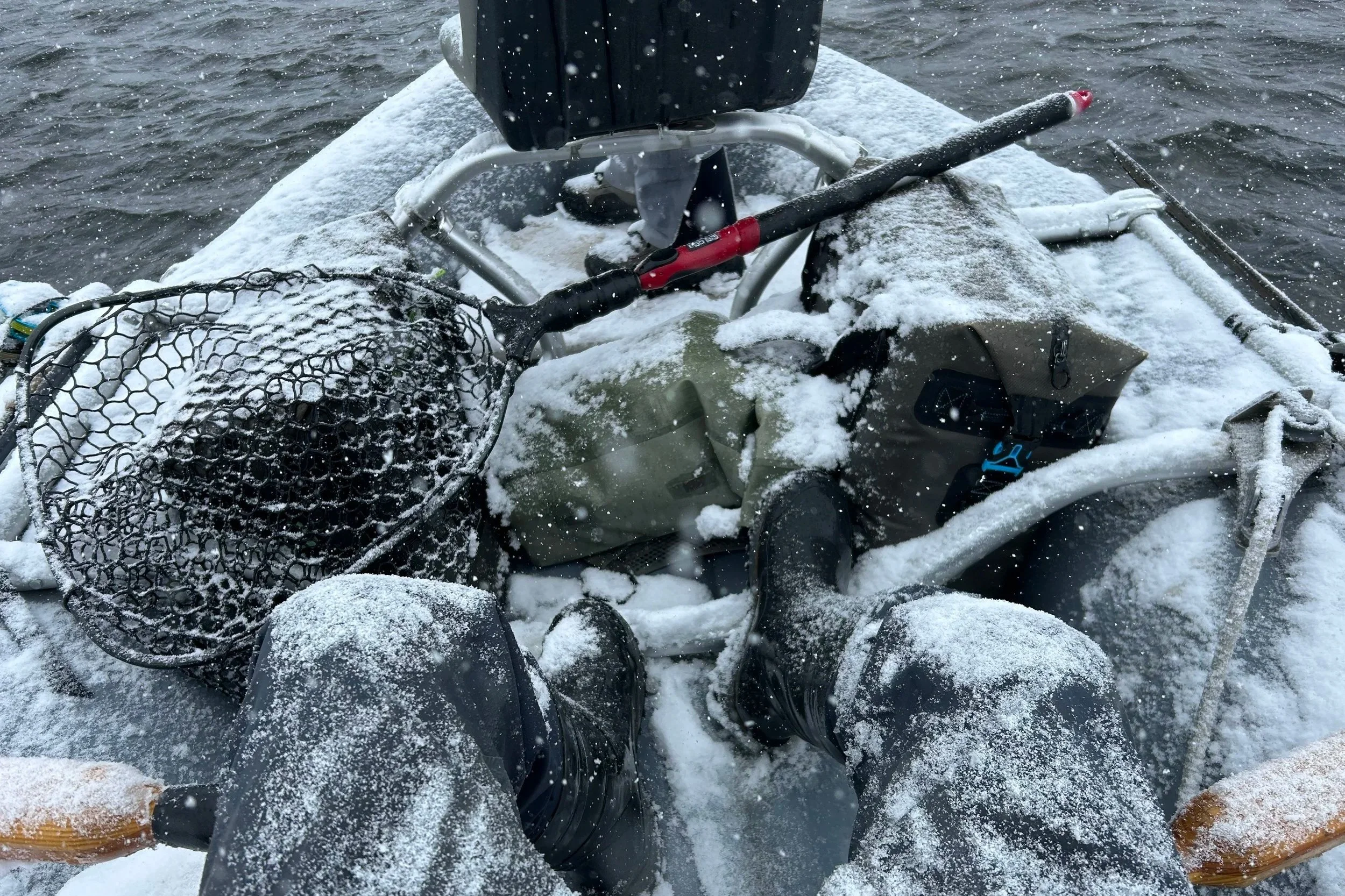 Flyshot Outfitters guide David Kern rowing through a heavy April snowstorm during a spring fishing report, proving that the best fishing often happens in Montana’s most unpredictable spring weather.