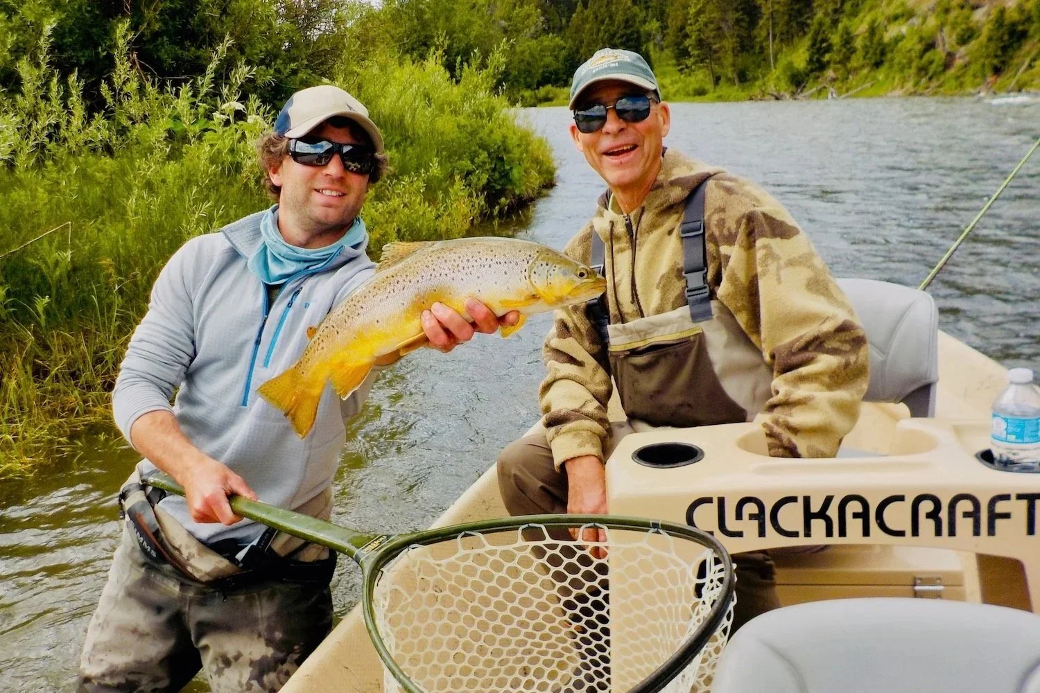 A gentleman angler and guide David Kern smiling with a wild Madison River brown trout during a guided Montana float trip.