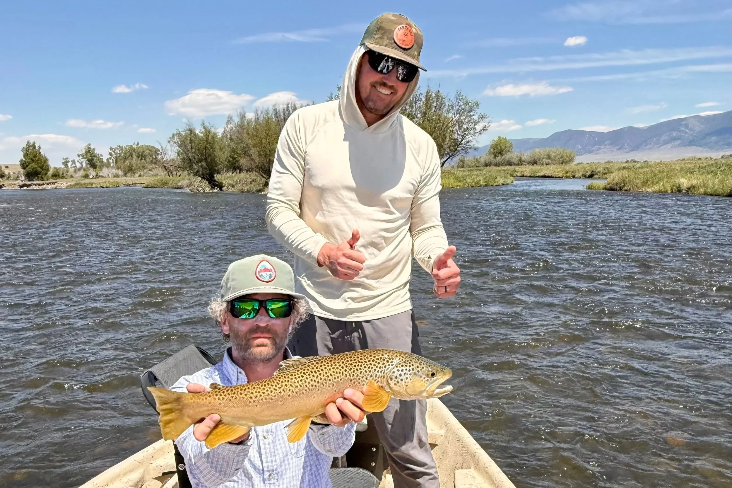 Close-up of a guide holding a brown trout caught on a streamer on the Madison River.