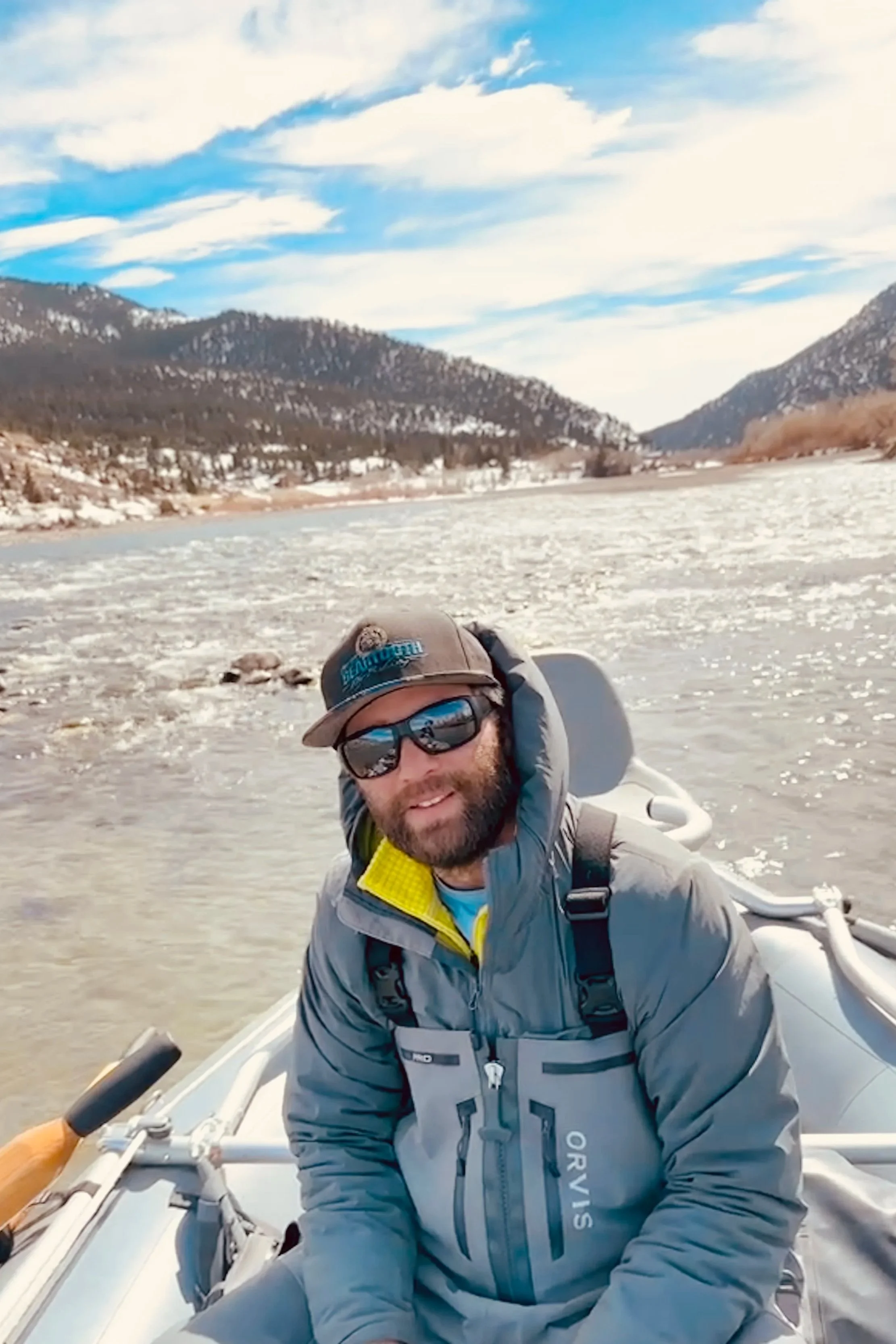 Flyshot Outfitters owner David Kern rowing a raft on the Yellowstone River during a scenic early spring fly fishing trip with snow-capped mountains near Livingston, MT.