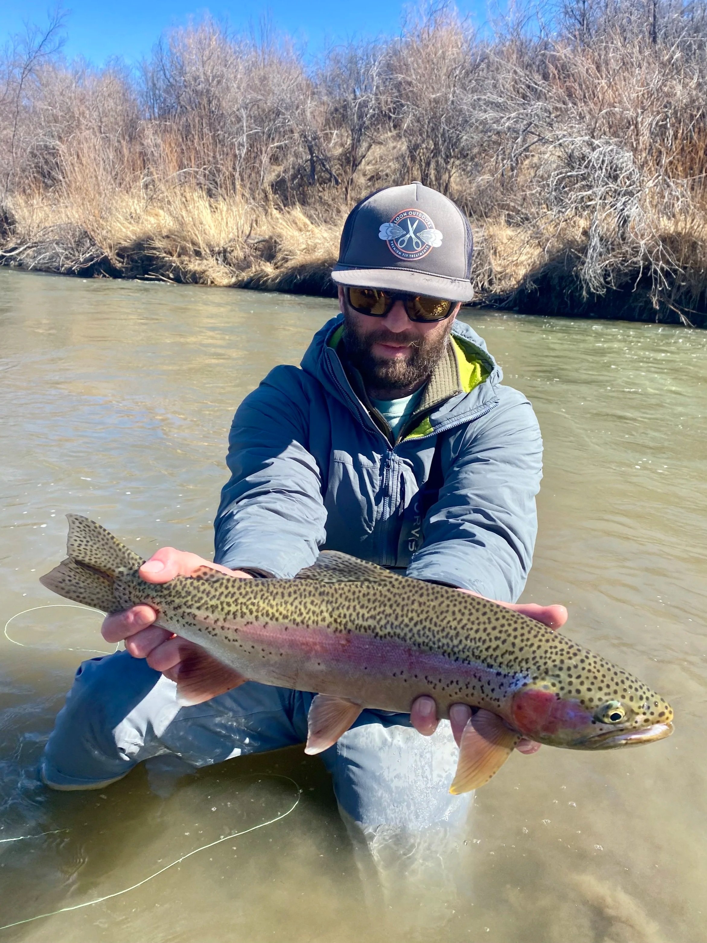 Flyshot Outfitters owner David Kern holding a beautiful, healthy pre-spawn rainbow trout on the Jefferson River during a guided spring fly fishing trip near Whitehall, Montana.