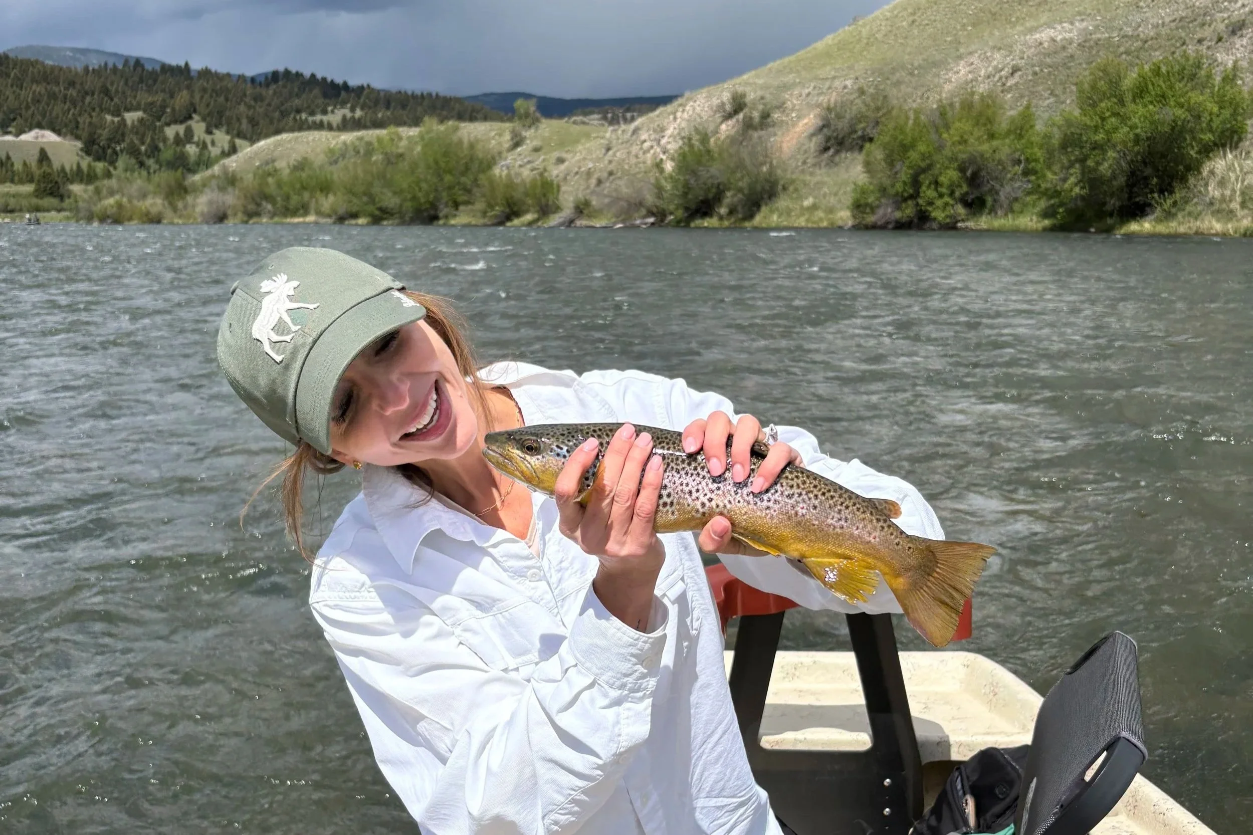 An angler admiring a wild brown trout during a spring streamer trip on the Upper Madison.