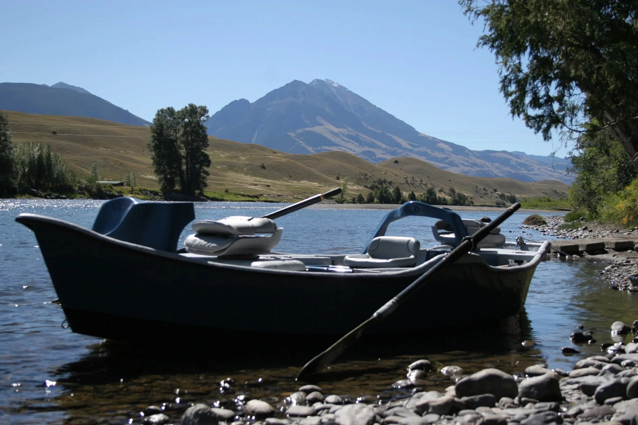 An anchored drift boat on the Yellowstone River in Paradise Valley, Montana, with the scenic Absaroka Mountains in the background during a guided fly fishing trip with Flyshot Outfitters.