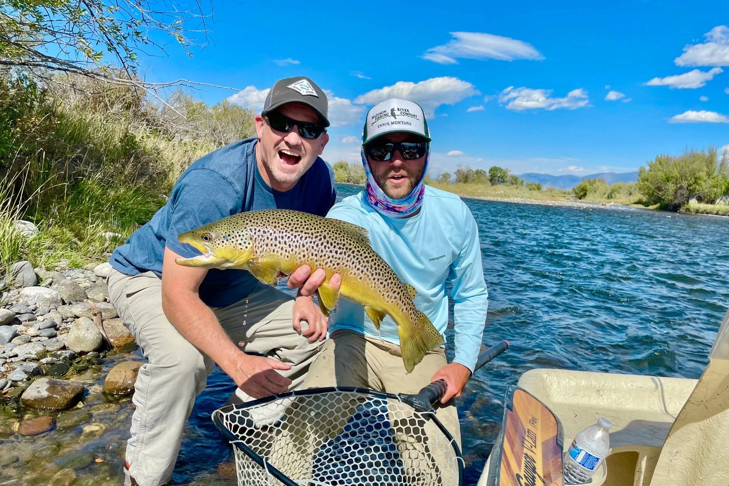 Smiling client and Flyshot Outfitters guide displaying a healthy Madison River brown trout during a professional Montana float trip.