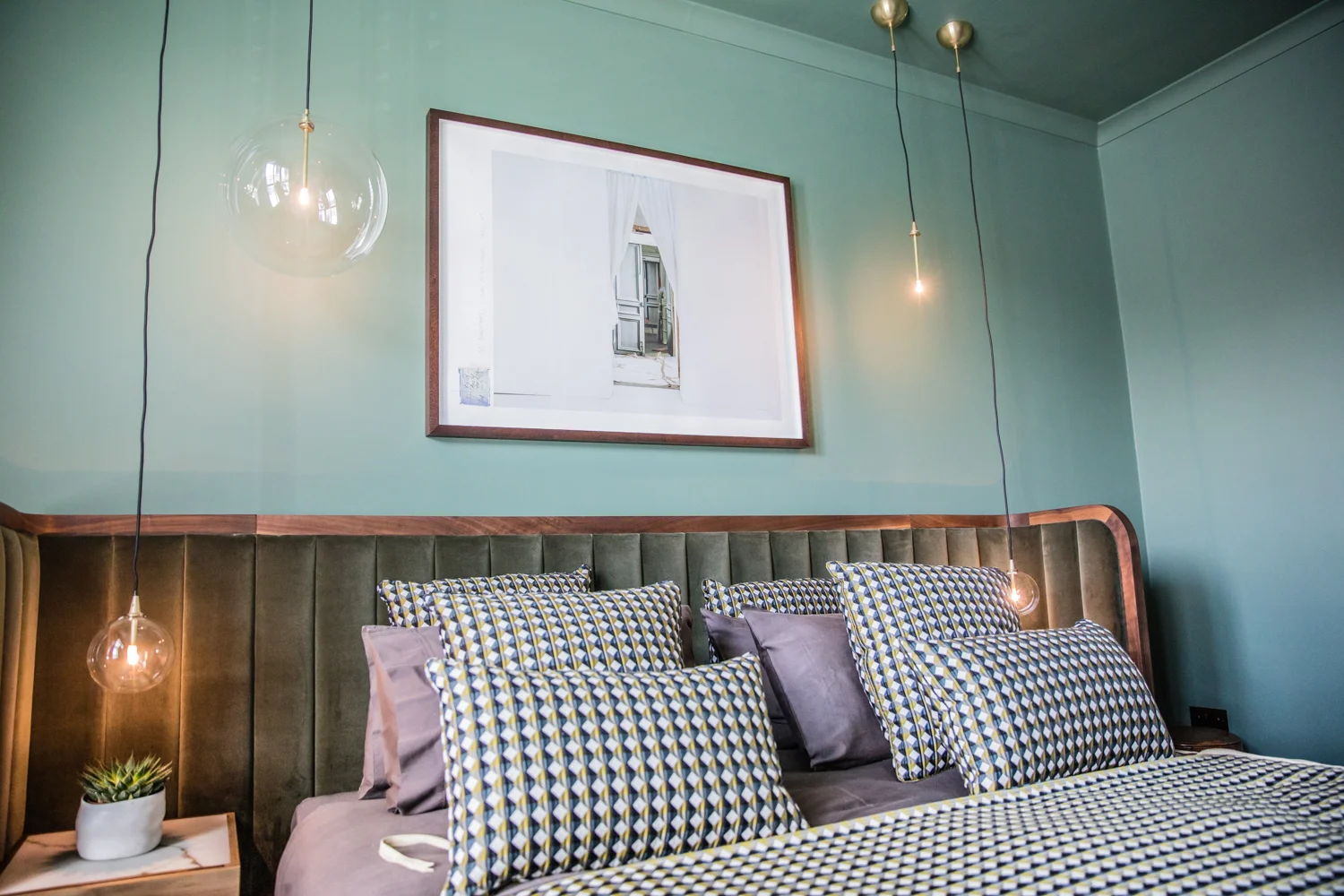 This gorgeous green bedroom is painted in Steam Engine by Crown Paints
