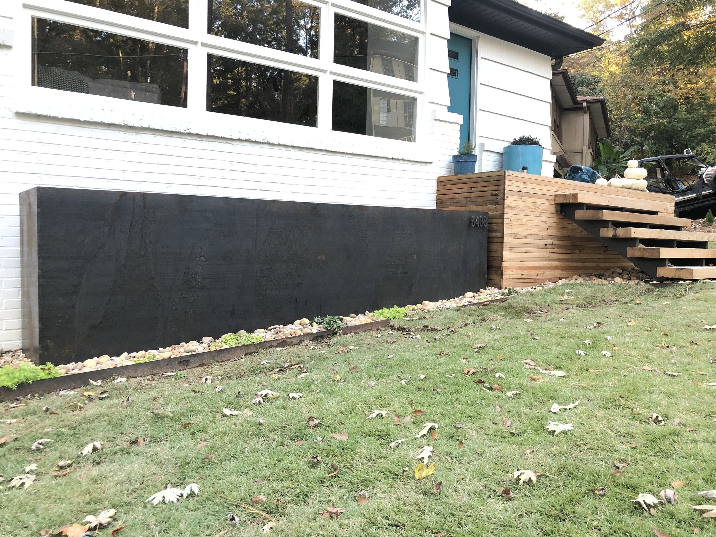 Corten steel planter with house number.