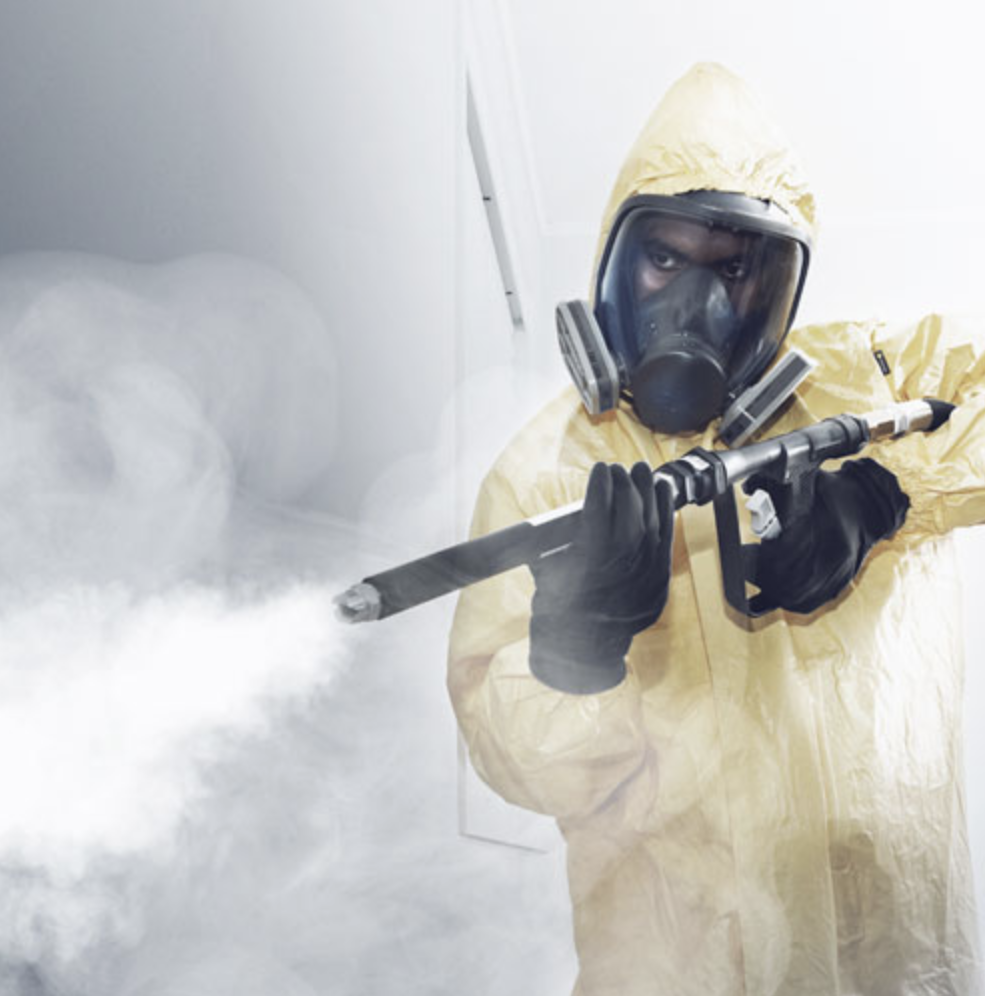 Man holding fogging gun performing meth decontamination
