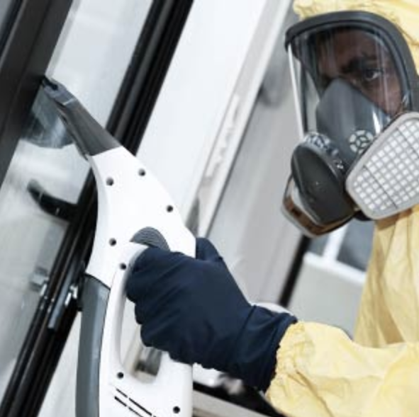 Man in yellow hazmat suit cleaning up after a biohazard incident