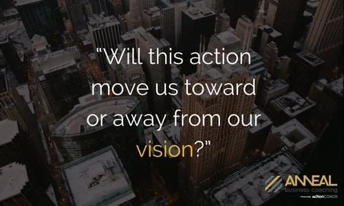 Anneal Business Coaching graphic from Martin Holland reading "Will this action move us toward or away from our vision?" over an aerial view of a city skyline at night.