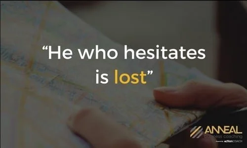 Anneal Business Coaching graphic from Martin Holland reading "He who hesitates is lost," over a close-up of hands holding a map.