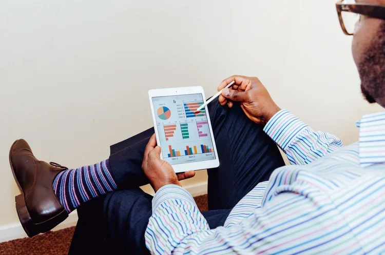 Business owner reviewing profit and loss statement and statement of cash flows on tablet to understand financial statements
