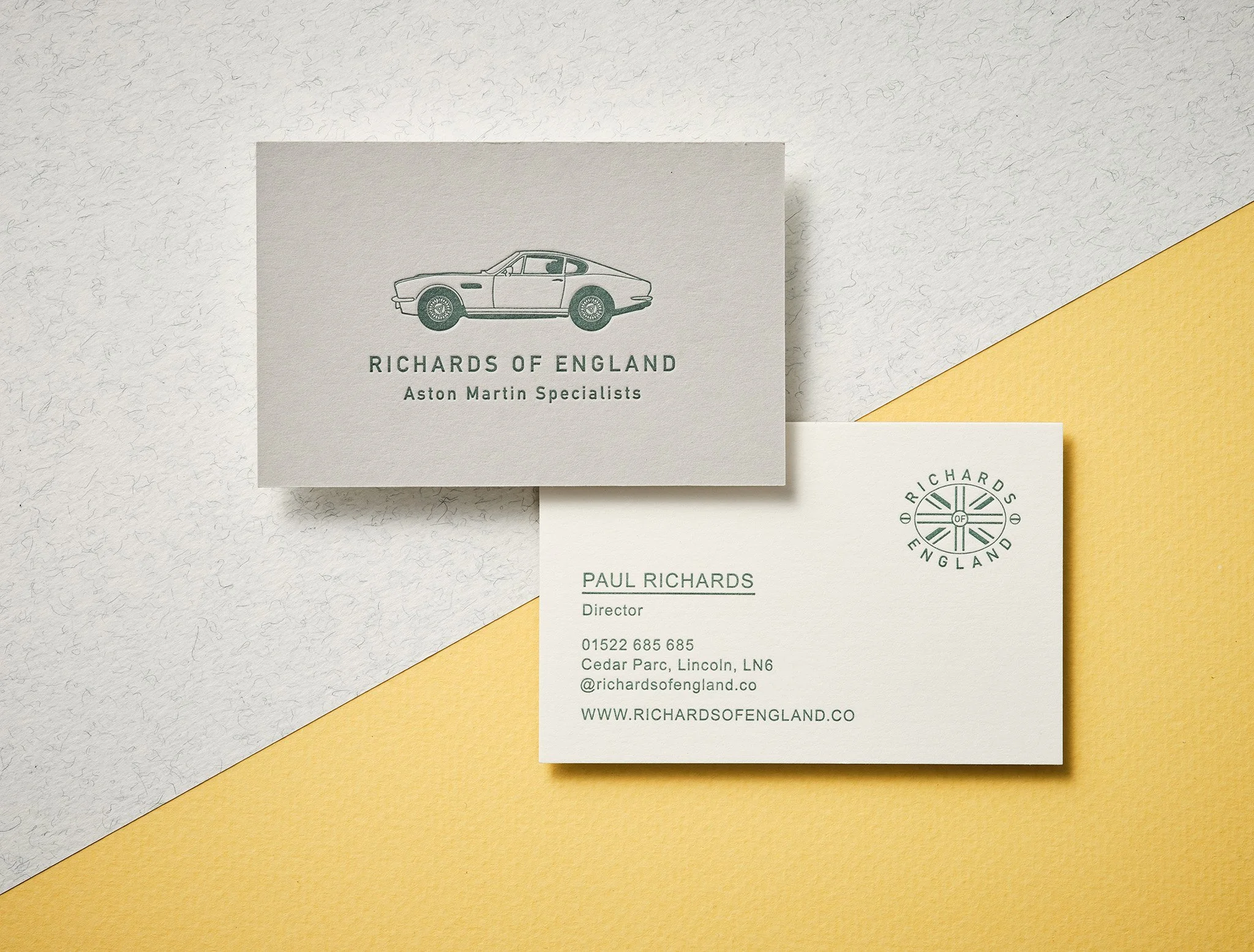 Green letterpress business card on heavyweight white duplex stock with debossed texture
