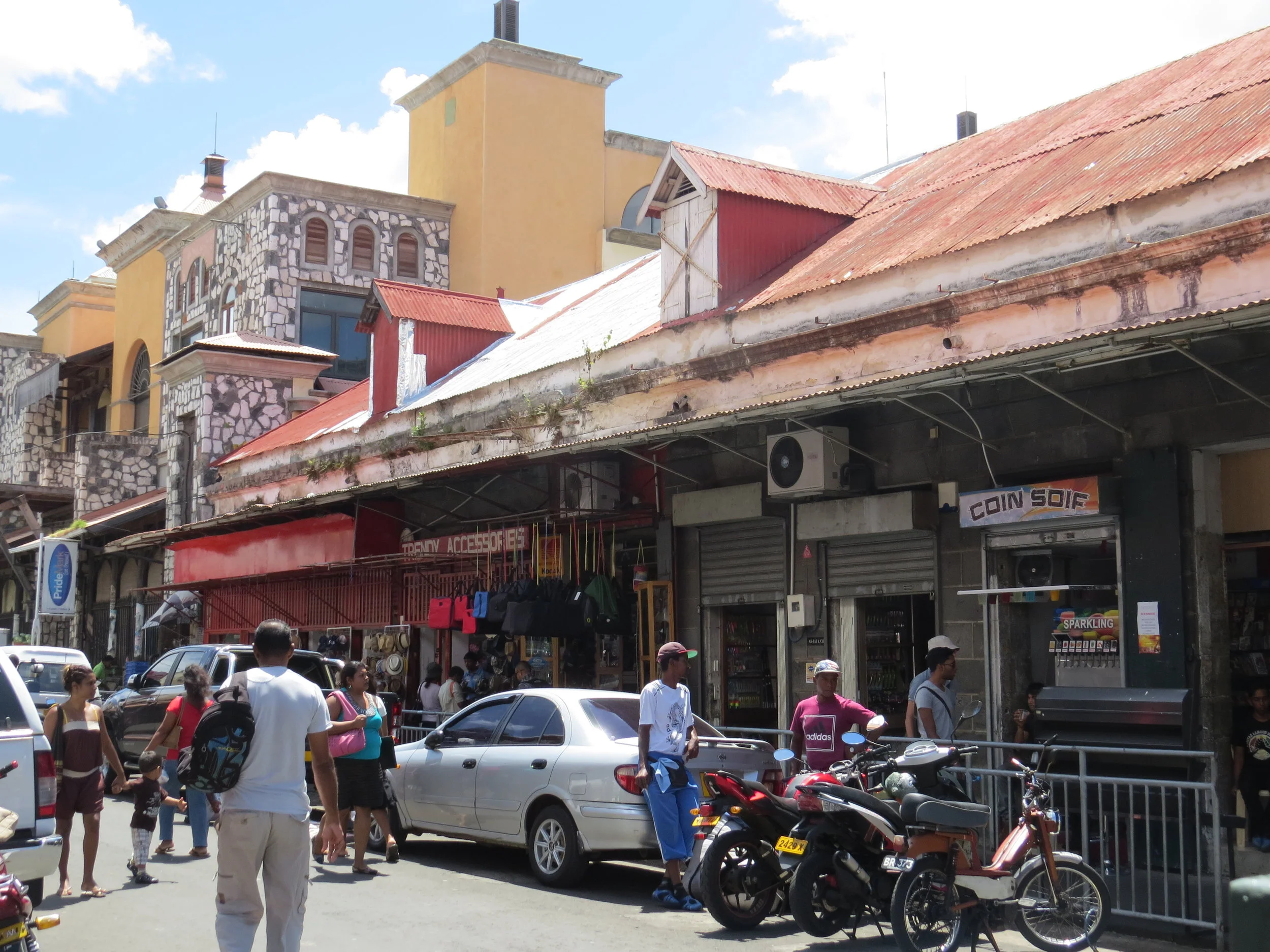 The streets are congested and pedestrian traffic overflows the narrow sidewalks which are crammed with vendor's wares.