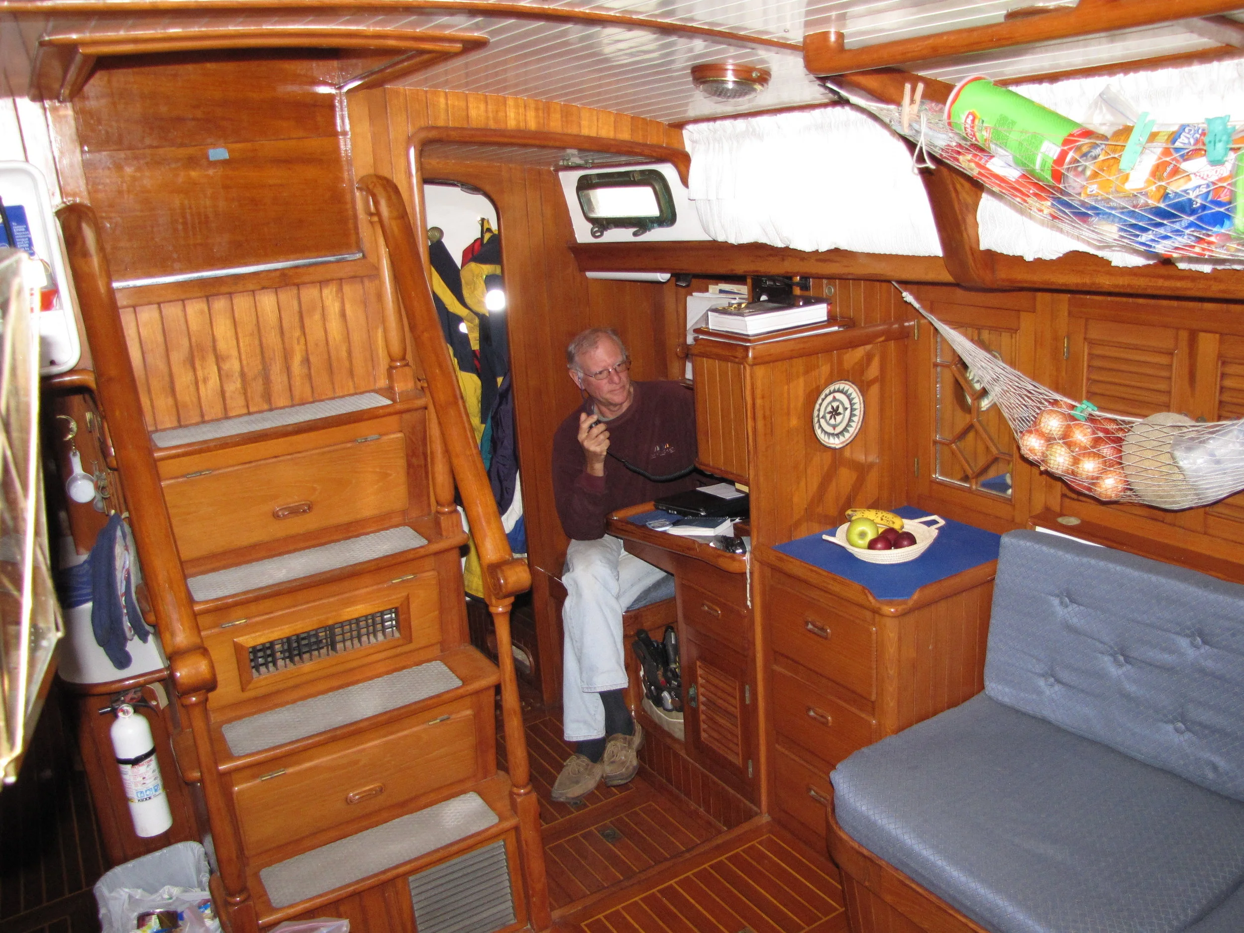An elegant teak ladder leads below decks into a well-appointed saloon. No need to duck ... there's plenty of headroom ... ~76" worth.