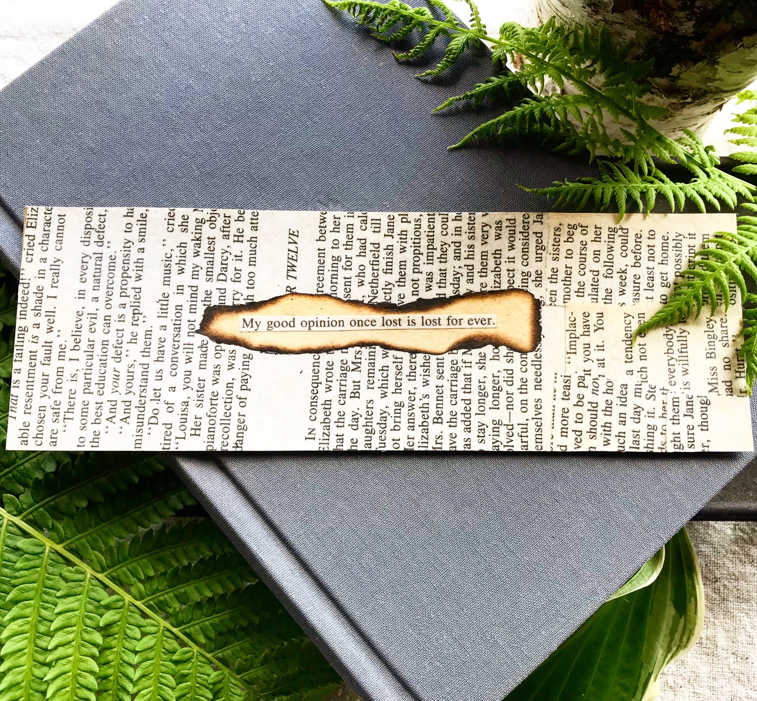 Pride & Prejudice Quote Bookmark on top of a book laying on a bed or ferns