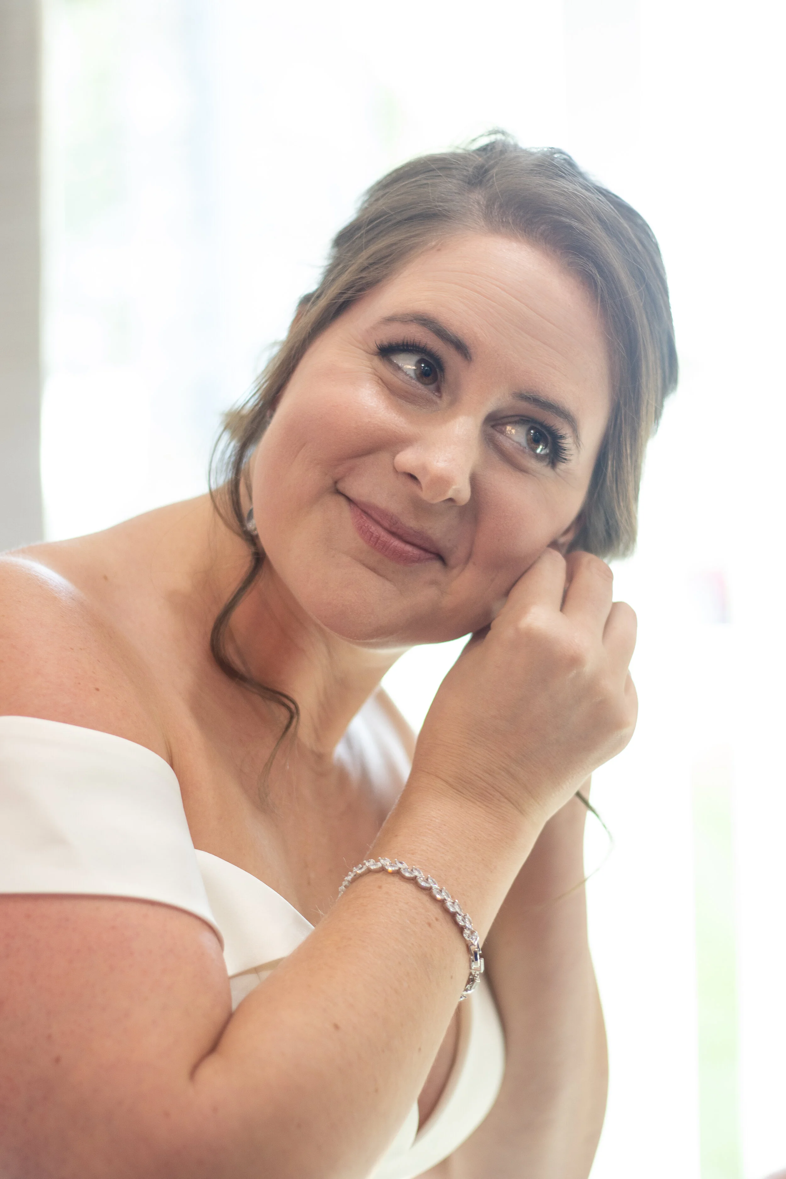 Lauren adds jewelry to her bridal look.