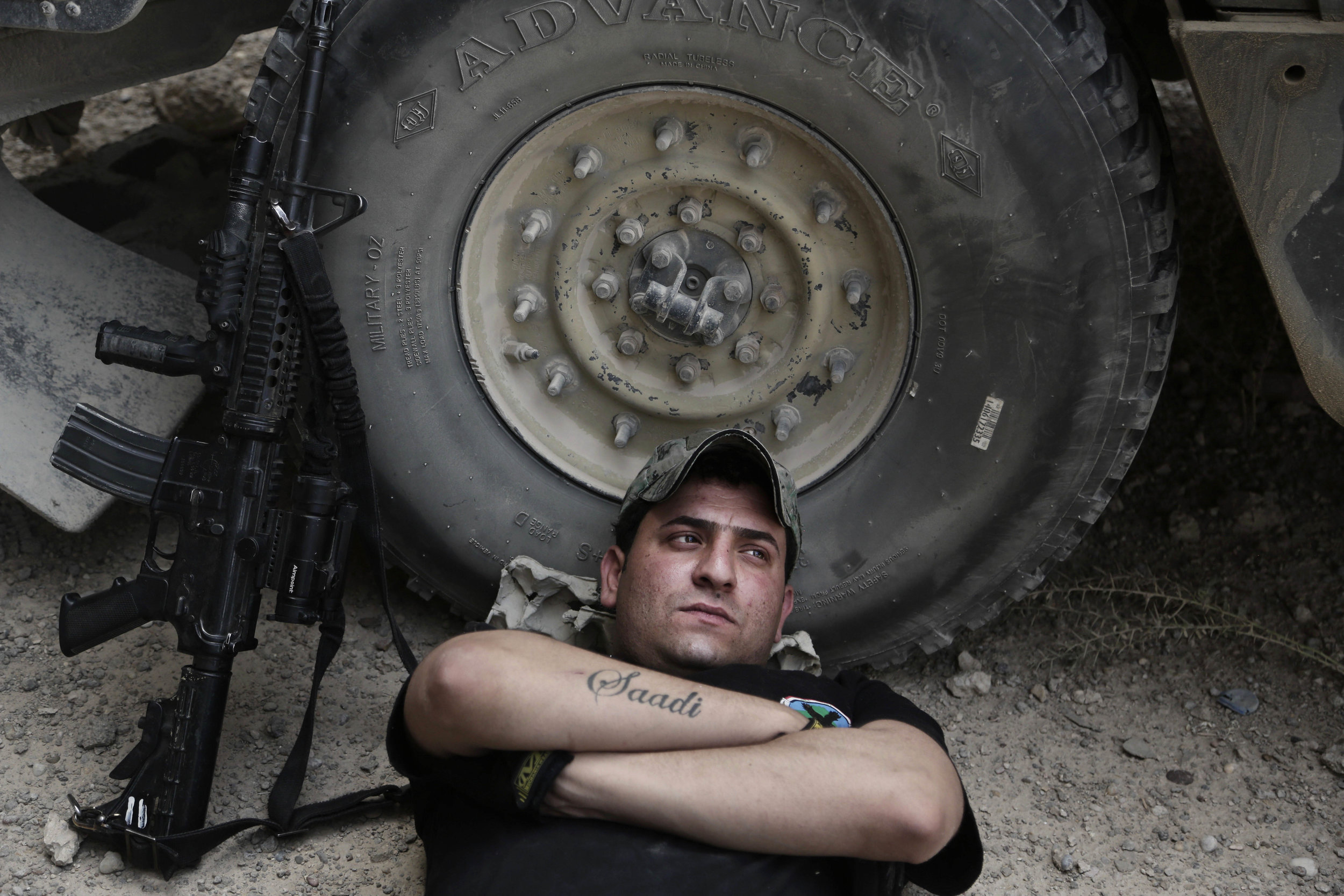 Sgt. Ahmed Kamel rests during the midday heat at a battle position on the southern edge of Fallujah. He has three tattoos: the name of his brother, Saadi, who was killed by the Mahdi Army in 2008, the name of a comrade, Namar, who was killed fightin