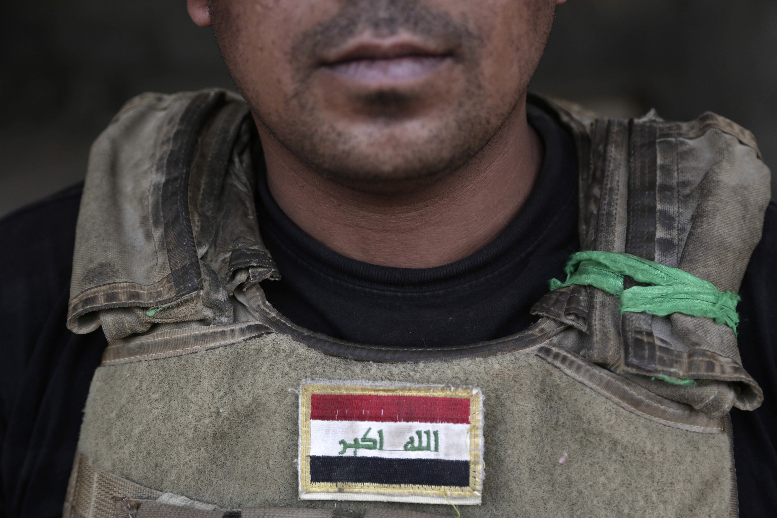 1st Sgt. Malik Jaber wears green cloth from the revered Imam Abbas shrine on his body armor, at a front line position on the southern edge of Fallujah, Iraq. He says he credits the holy object with saving his life when the Special Forces were fighti