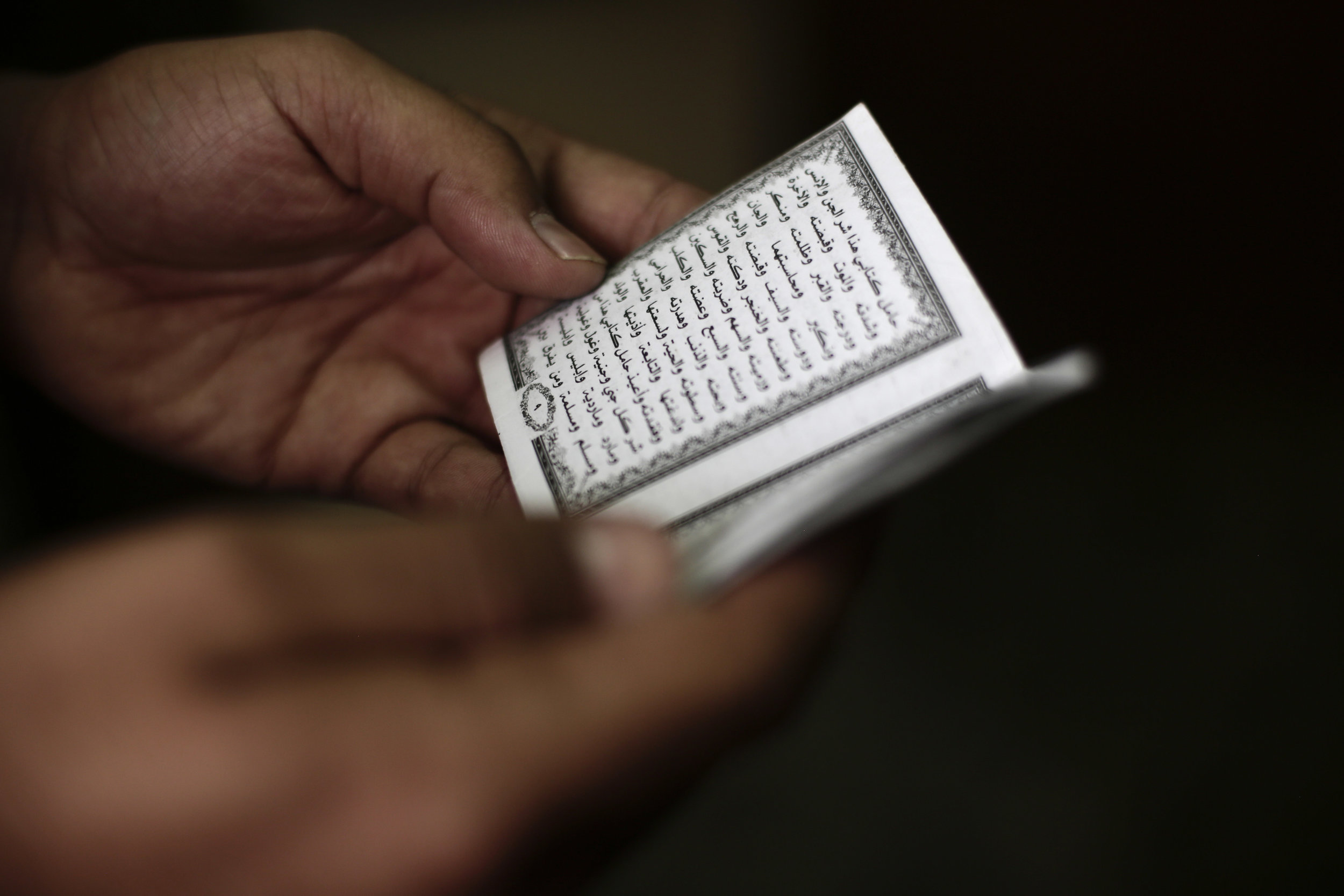 Cpl. Mustafa Saada shows an Islamic prayer book he carries as a good luck charm.