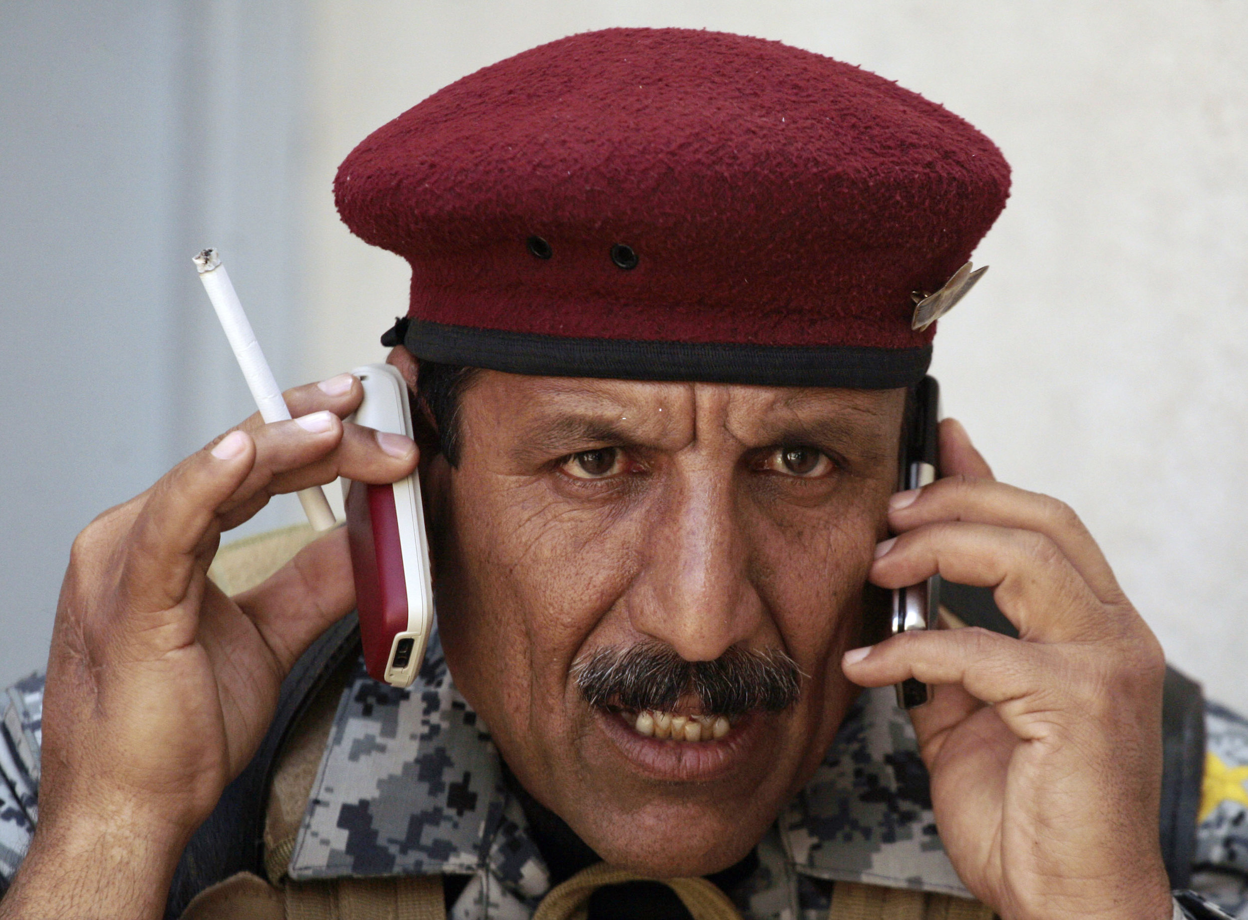 Iraqi National Police Col. Moslet Ahmed Attiya fields phone calls about a suicide bombing during a joint search operation with U.S. troops in Mosul, March 17, 2009.