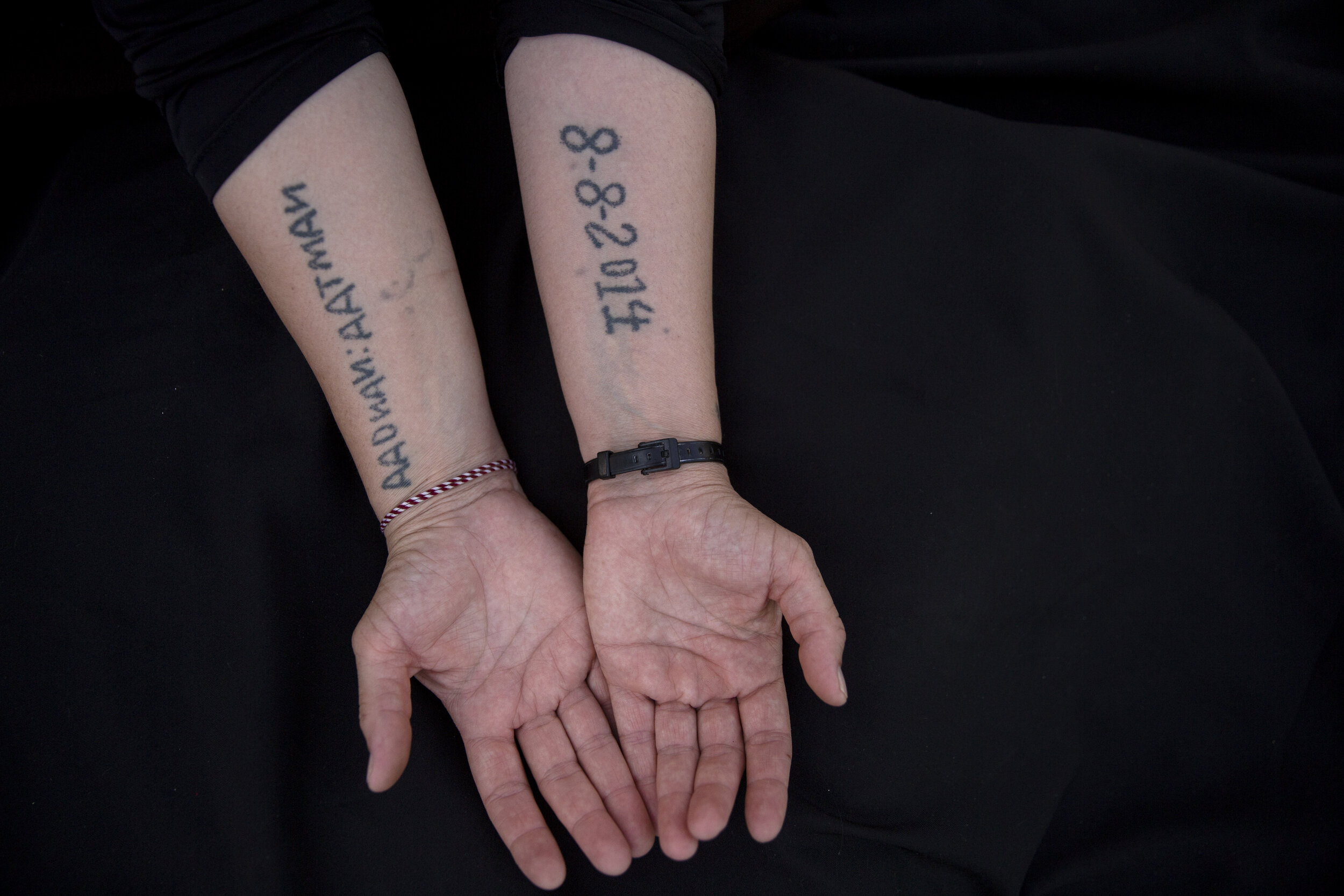 Leila Shamo displays tattoos she made while enslaved by Islamic State militants at her home near Khanke Camp, near Dohuk, Iraq. Shamo, 34, used her breast milk, charcoal ash and a needle to write the names of her husband, and two sons on the front