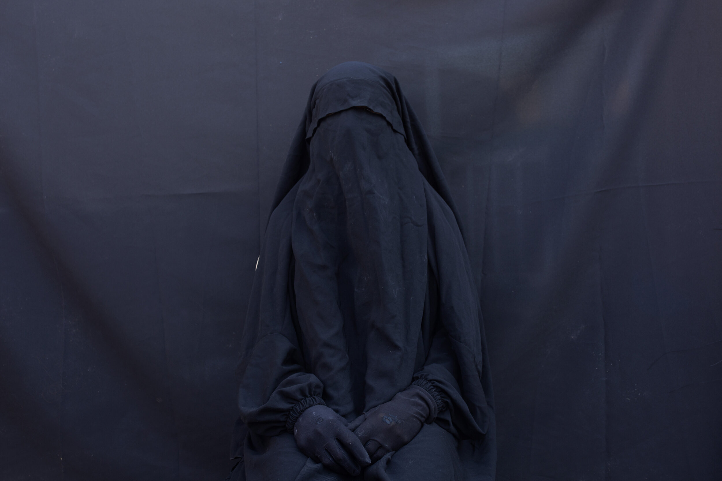 Layla Taloo poses for a portrait in the full-face veil and abaya she wore while enslaved by Islamic State militants, at her home in Sharia, Iraq. Her ordeal in captivity underscores how IS members continually ignored the rules the group tried to imp