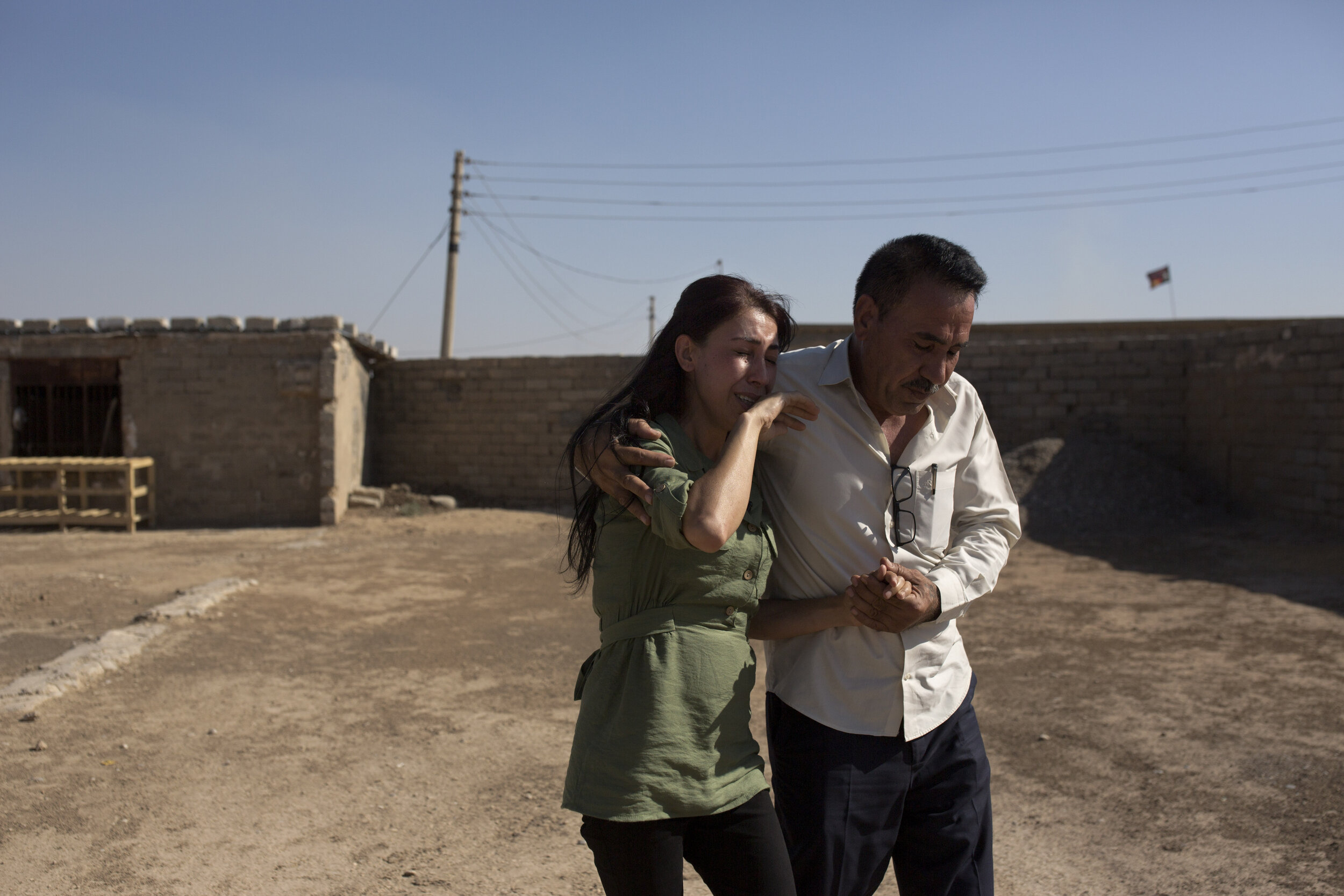 Layla Taloo is overcome with grief as her brother, Khalid, leads her away from the compound where she last saw her husband in 2014 after the family was captured by Islamic State militants in Tal Afar, Iraq. Her family was taken to a village with nea