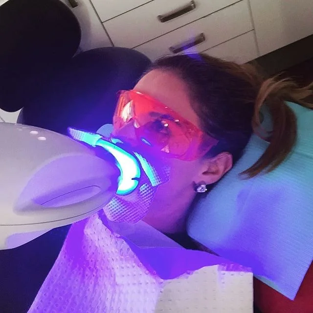 female with brown hair getting teeth professionally whitened