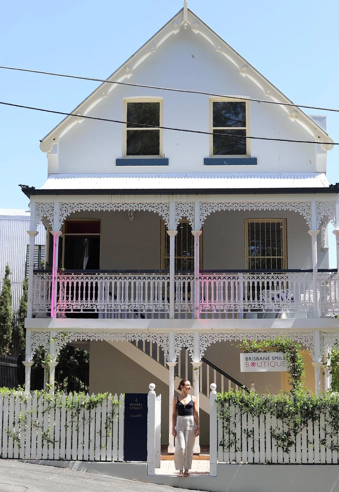 a young woman standing out the front of Brisbane Smile Boutique, one of Brisbane's most exclusive aesthetic dental practices with dedicated teeth whitening boutique studios