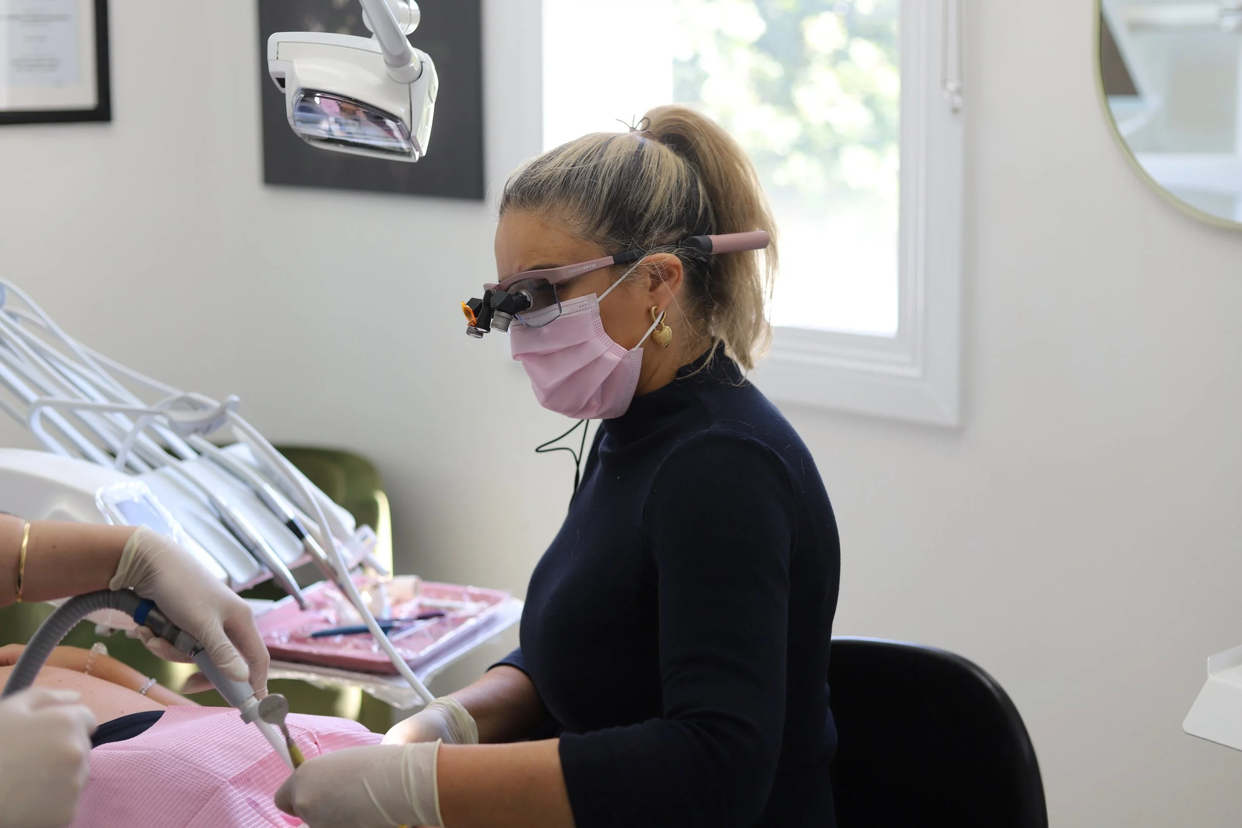 Female dentist with masks and loupes on at Brisbane Smile Boutique