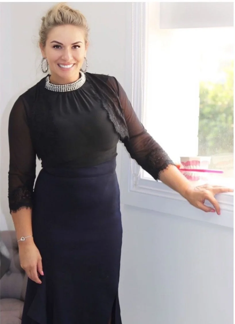 a female dentist, dr Leila Haywood at Brisbane Smile Boutique, one of Brisbane's leading cosmetic dentists, is a woman with blonde hair smiling at camera