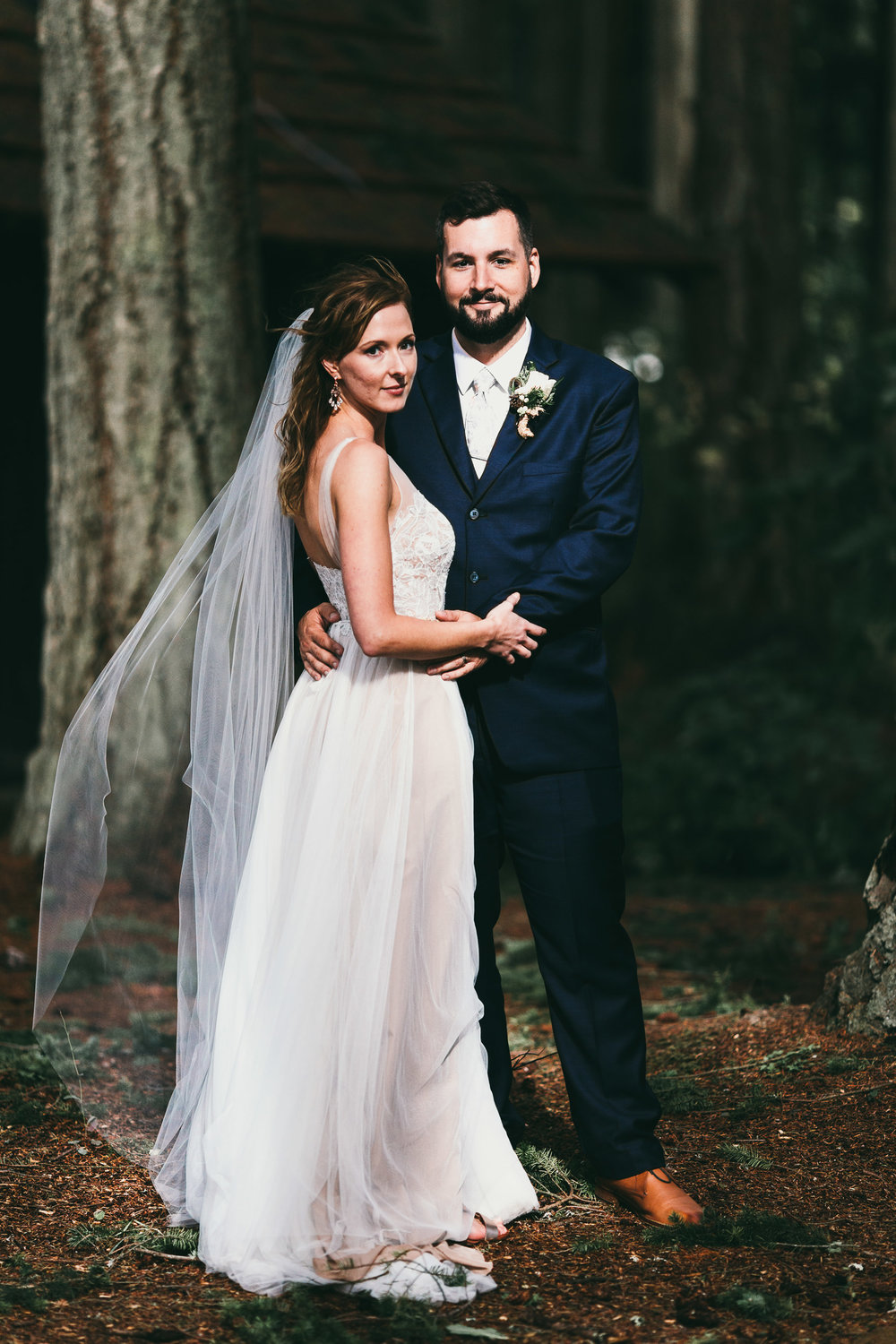 bride and groom in a sunny patch at kitsap memorial state park