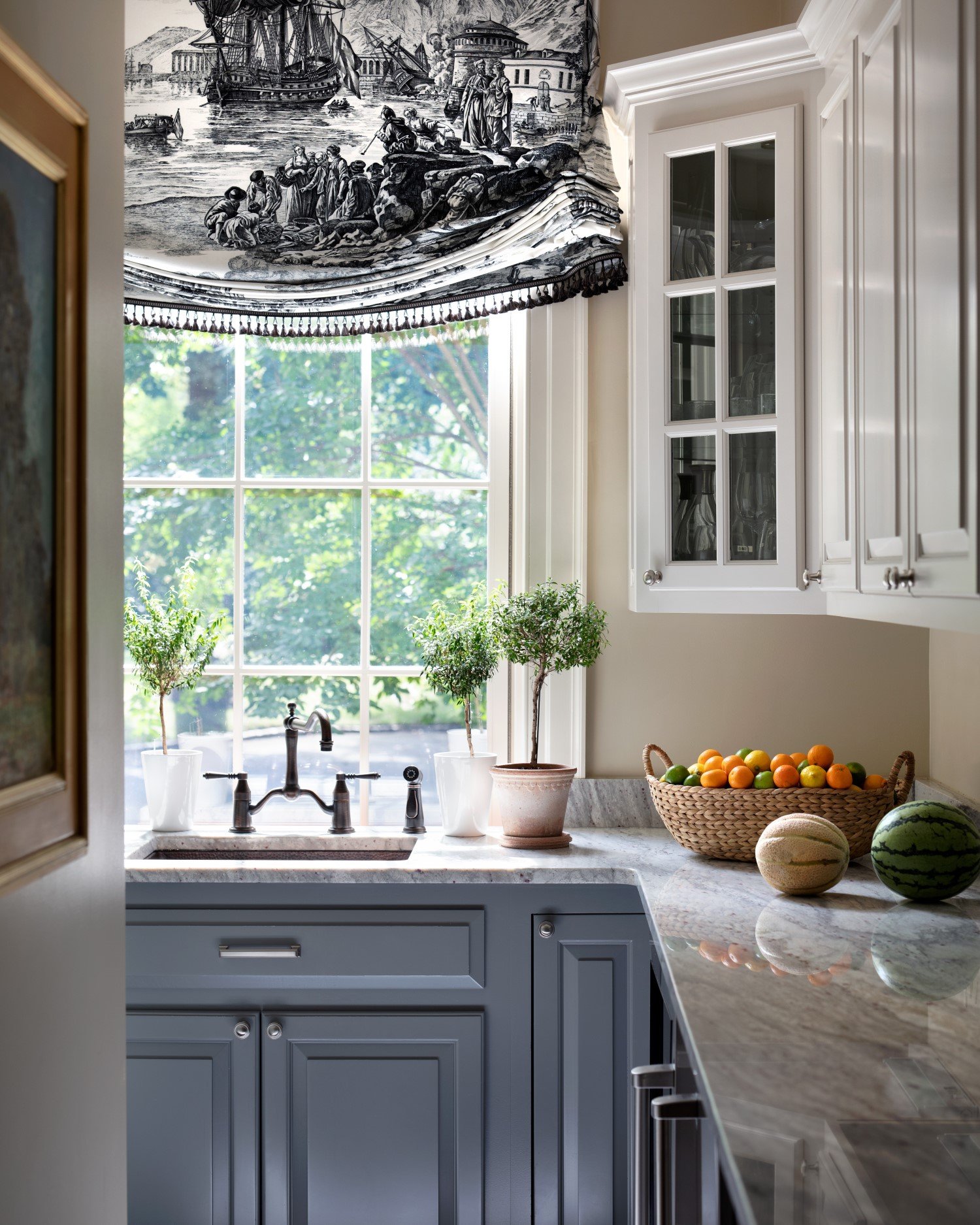  Kitchen vignette by Bridget Beari Designs with classical details in the French blue and white cabinetry and a sophisticate flounced roman shade in a black marine toile 