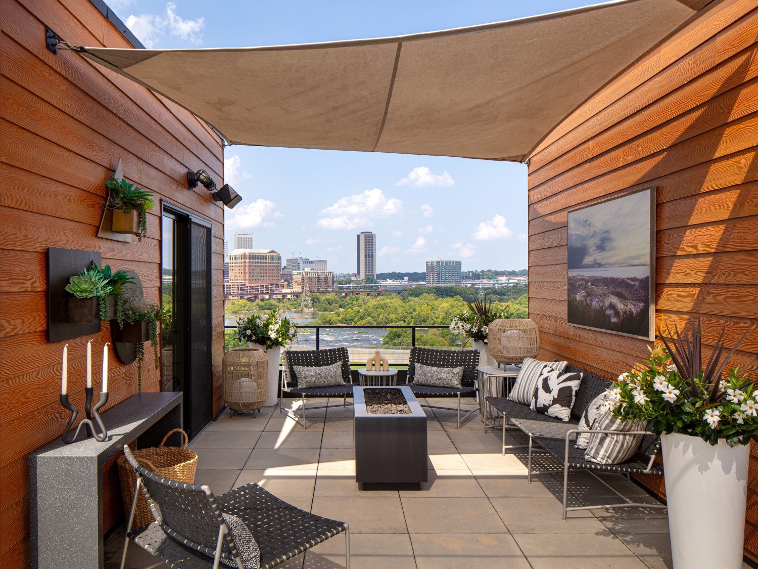  Rooftop living with a spectacular view! We created a chic outdoor space with wall-mounted and standing planters, accessories and furniture in muted tone to not compete with that skyline. 