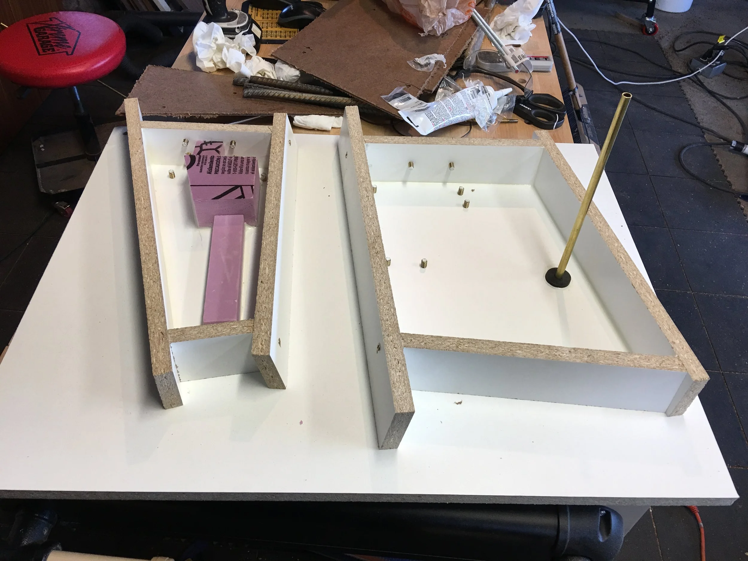 Forms done. The edges are sealed with silicone sealant and threaded brass embeds are located throughout for various pieces afterwards. The pink foam on the left will be removed after casting, which will leave a void for the motor assembly, while the brass rod on the right allows the spindle to be bolted through the table into the base for maximum rigidity. 