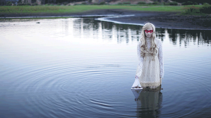 Cinemagraph Animated GIF of Girl with Toy Sail Boat in Water