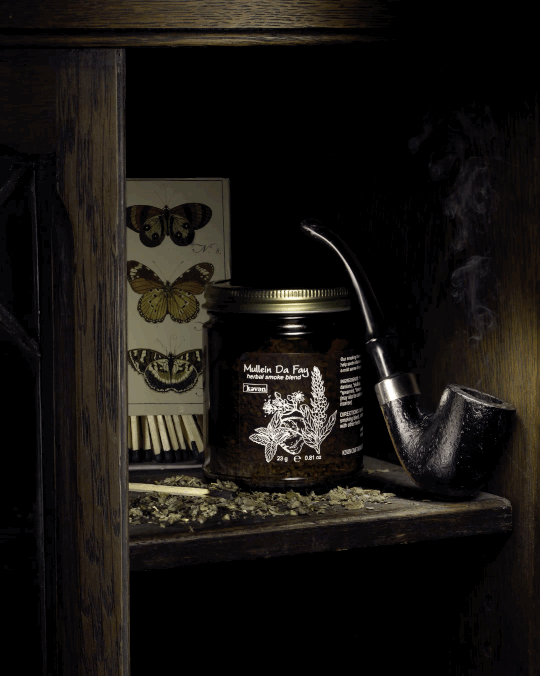 A herbal smoke blend styled in a dark wooden shelf with a vintage pipe and matches. Dark home goods produt photography.