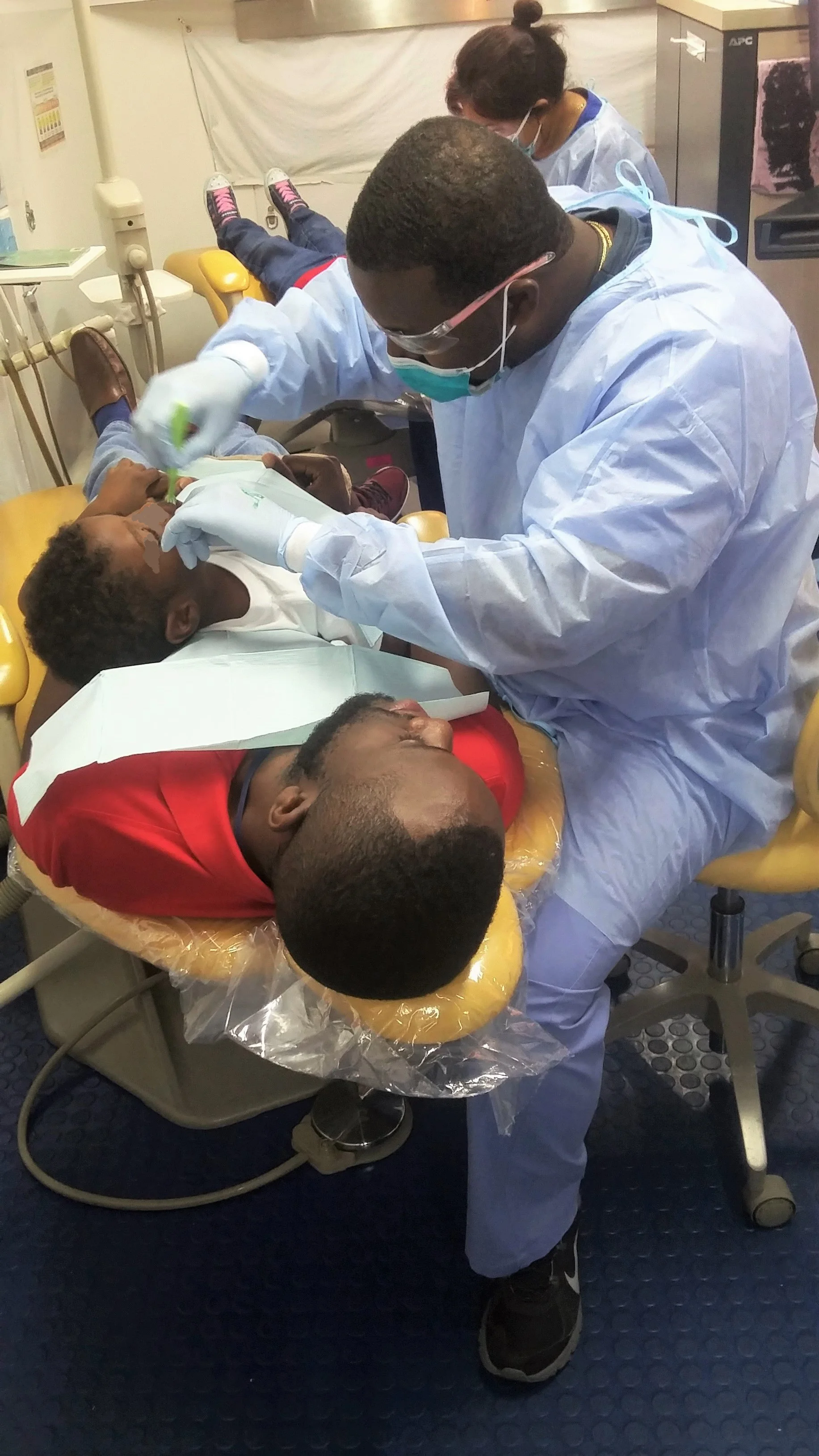 Hat's off to Curtiss Walker, a case manager in Manatee County, for going the extra mile by assuring the little man on his lap did not need to feel nervous about the dentist. Dr. Jerry Chery, DDS, works on the little man as he get's an exam and cleaning.
