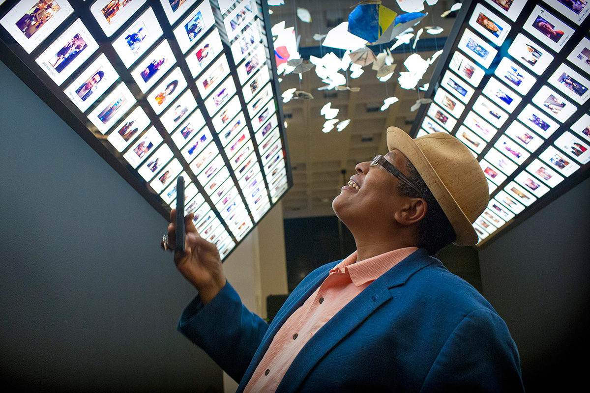 View of gallery showing light boxes featuring enlarged slides and origami butterflies.