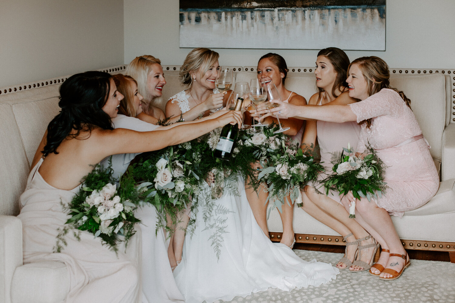 Bride and bridesmaids poppin’ champagne to celebrate a friends wedding before social distancing and quarantine existed with Wedding and Elopement photographer Diana Coulter