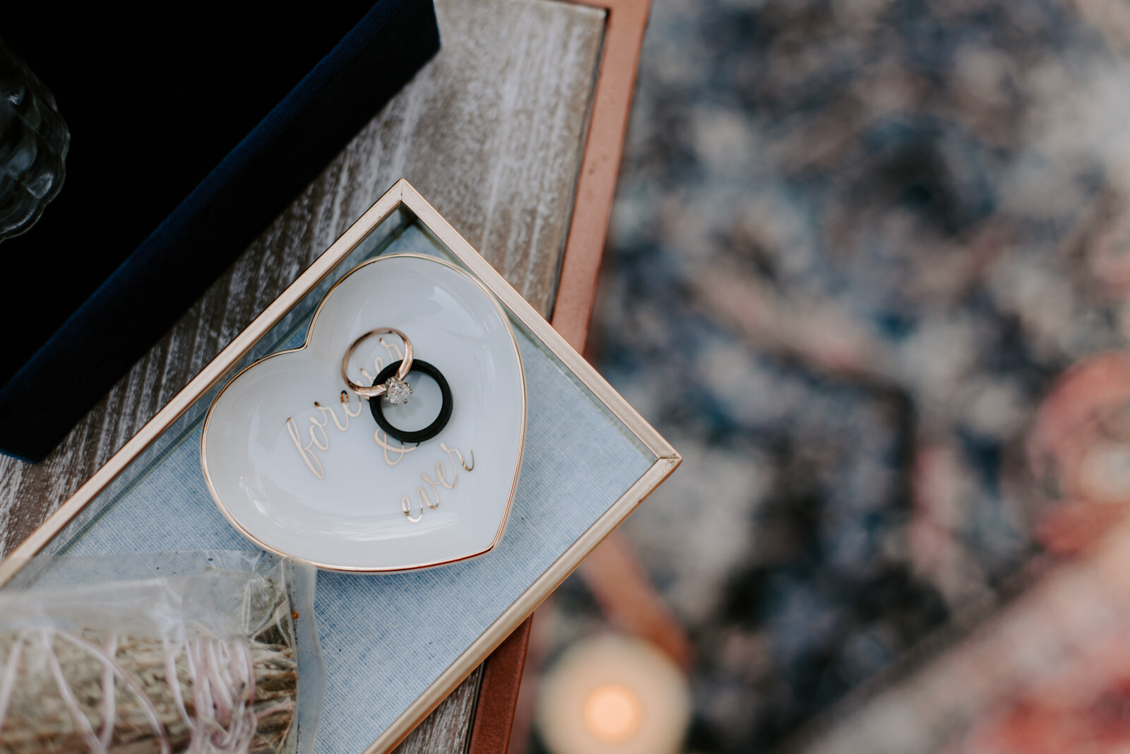 Detail flat lay of rings and ring tray with colorful boho rug in the background at Estes Park AirBnB Elopement for an LGBTQ couple with Colorado elopement photographer Diana Coulter
