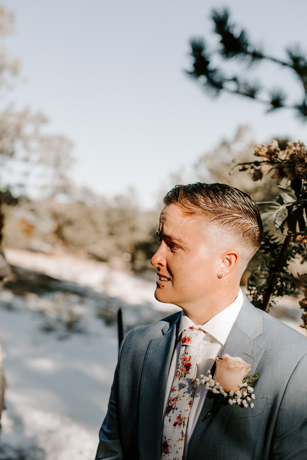 emotional groom/broom waiting at the end of the aisle and holding her hands while waiting for her bride to walk down the aisle at Estes Park AirBnB Elopement for an LGBTQ couple with Colorado elopement photographer Diana Coulter