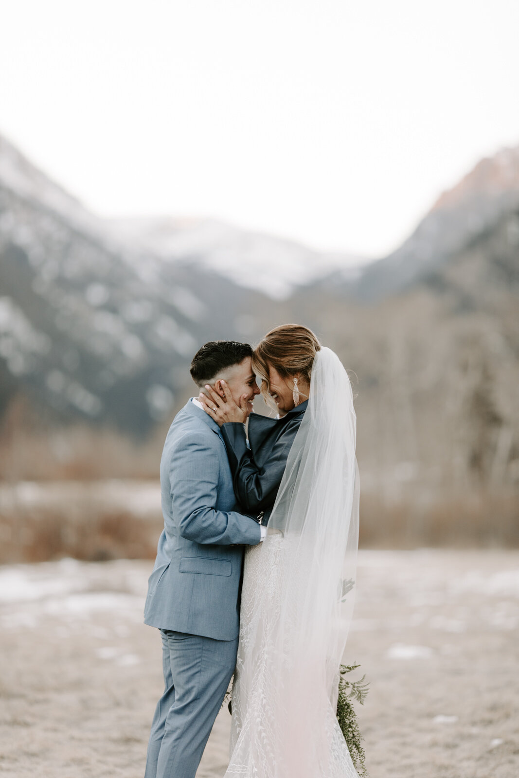 LQBTQ engaged in intimate connection during winter elopement in Rocky Mountain National Park in Colorado at sunset with wedding photographer Diana Coulter