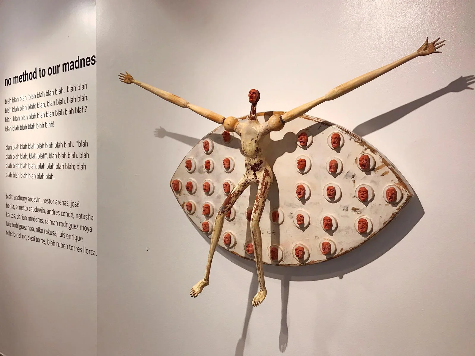 an image of the vinyl wall title of the art exhibition no method to our madness curated by Stacy Conde for Conde Contemporary, sculpture of man with interchangeable clay heads by Ernesto Capdevila