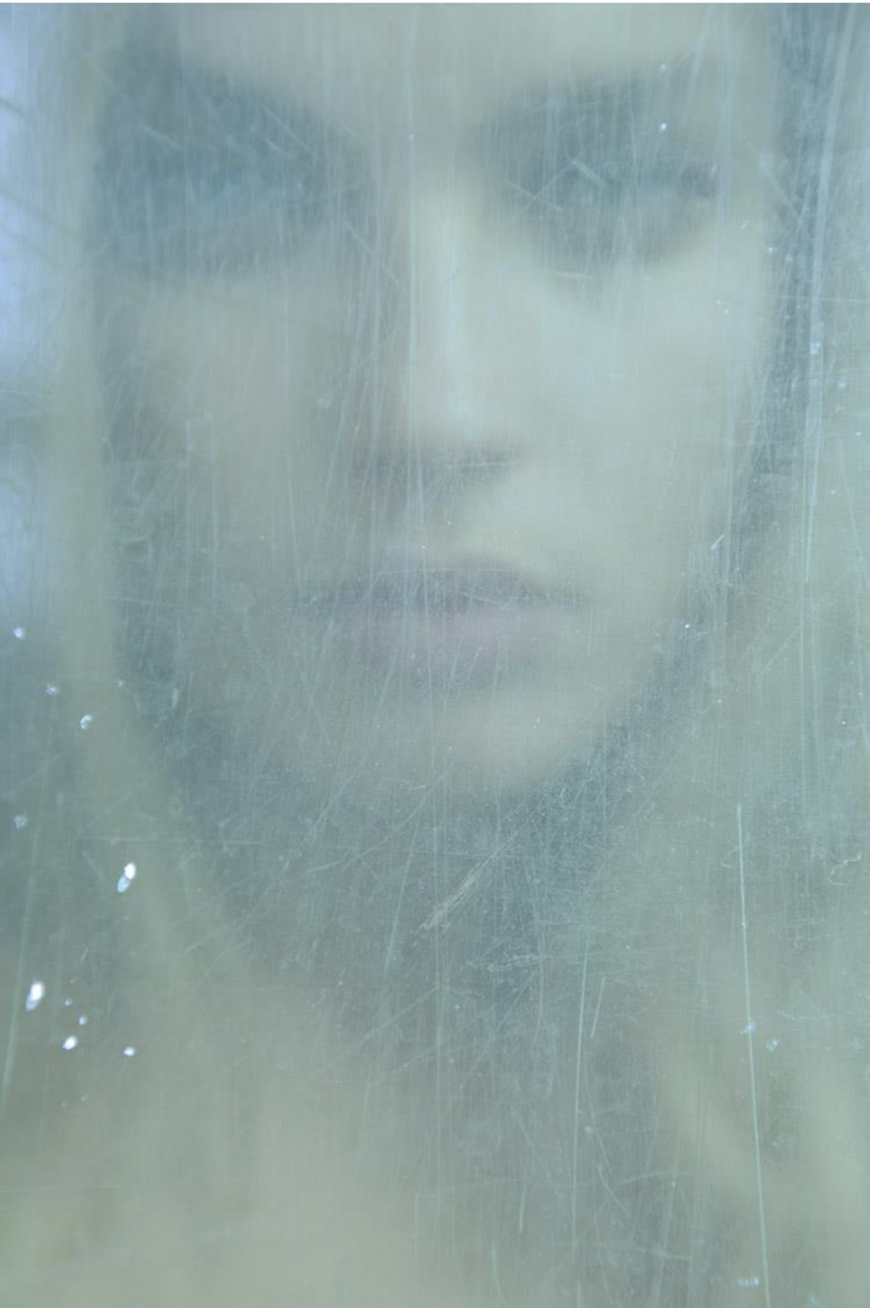 A photograph, titled Anna, of a beautiful woman behind scratched pale blue plexi by contemporary Russian photographer Natasha Kertes, available at Conde Contemporary.
