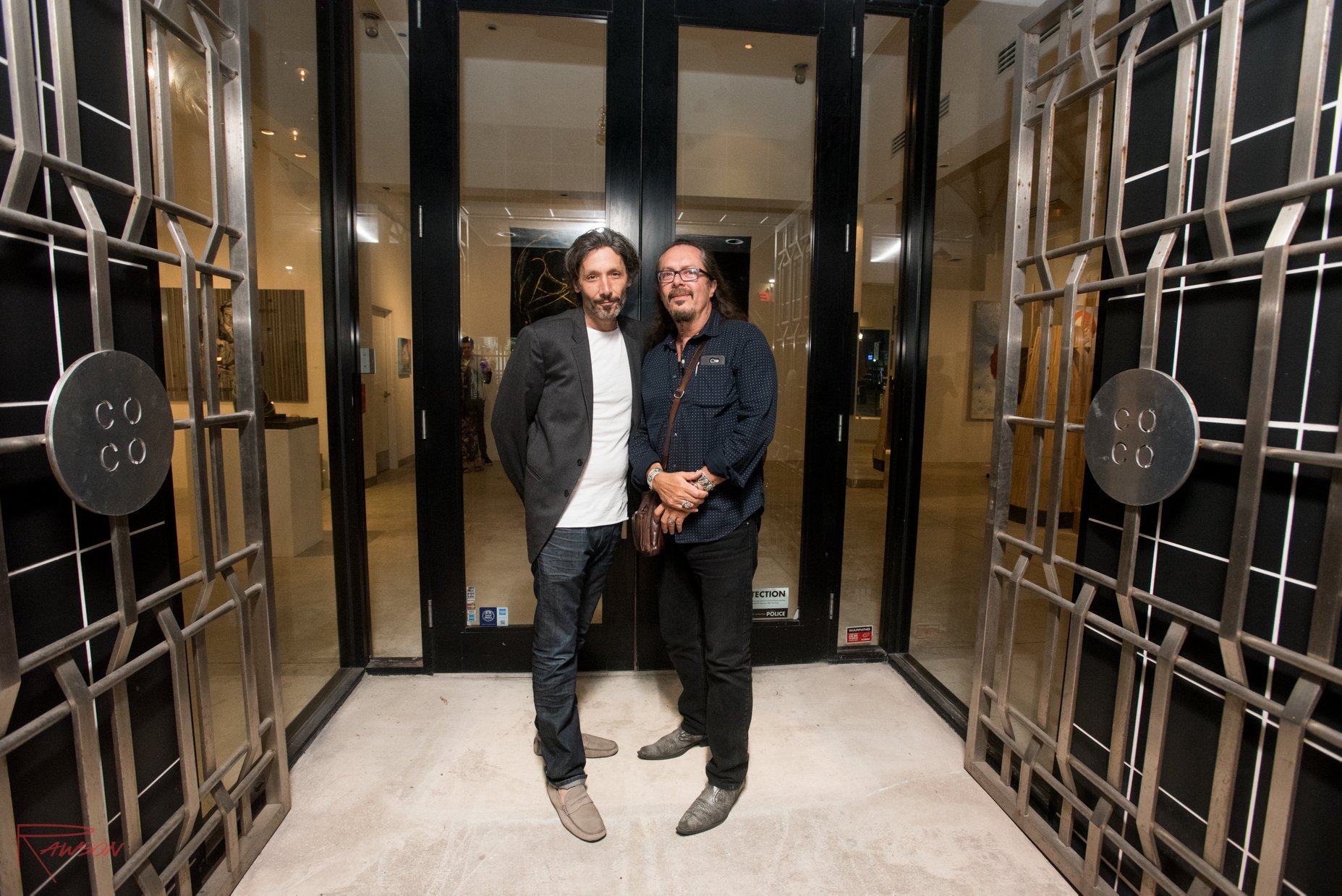 Contemporary Cuban artists Andrés Conde and José Bedia stand at the doors of Conde Contemporary's former location in Miami Beach, at the old Versace store.